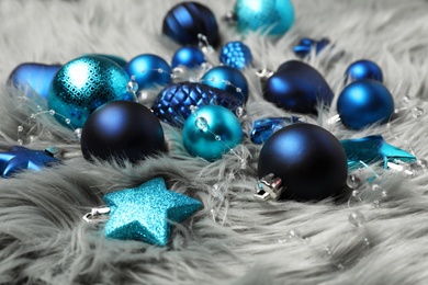 Beautiful Christmas baubles on grey faux fur, closeup