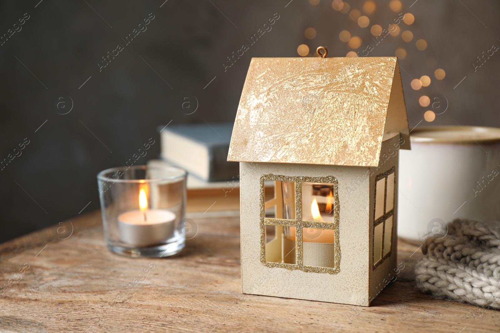 Photo of Composition with house shaped candle holder on wooden table. Christmas decoration