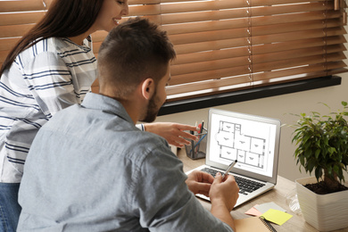 Image of Architects making project of house on laptop in office