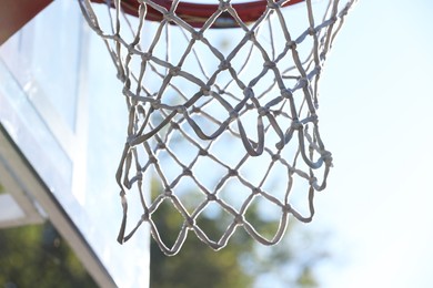 Photo of Basketball hoop with net outdoors on sunny day, closeup
