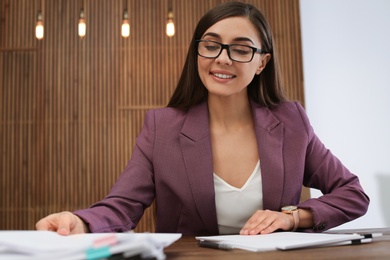 Photo of Beautiful businesswoman working with documents at table in office