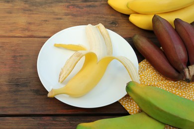 Many different delicious bananas on wooden table