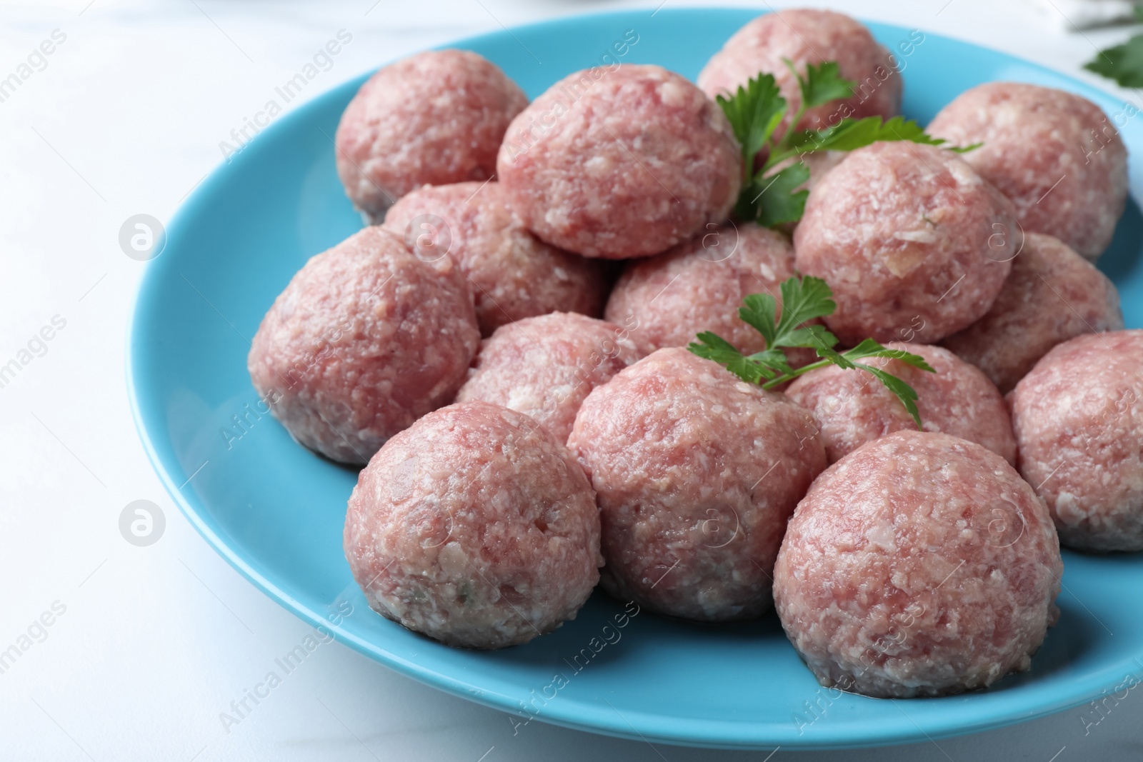 Photo of Many fresh raw meatballs on white table, closeup