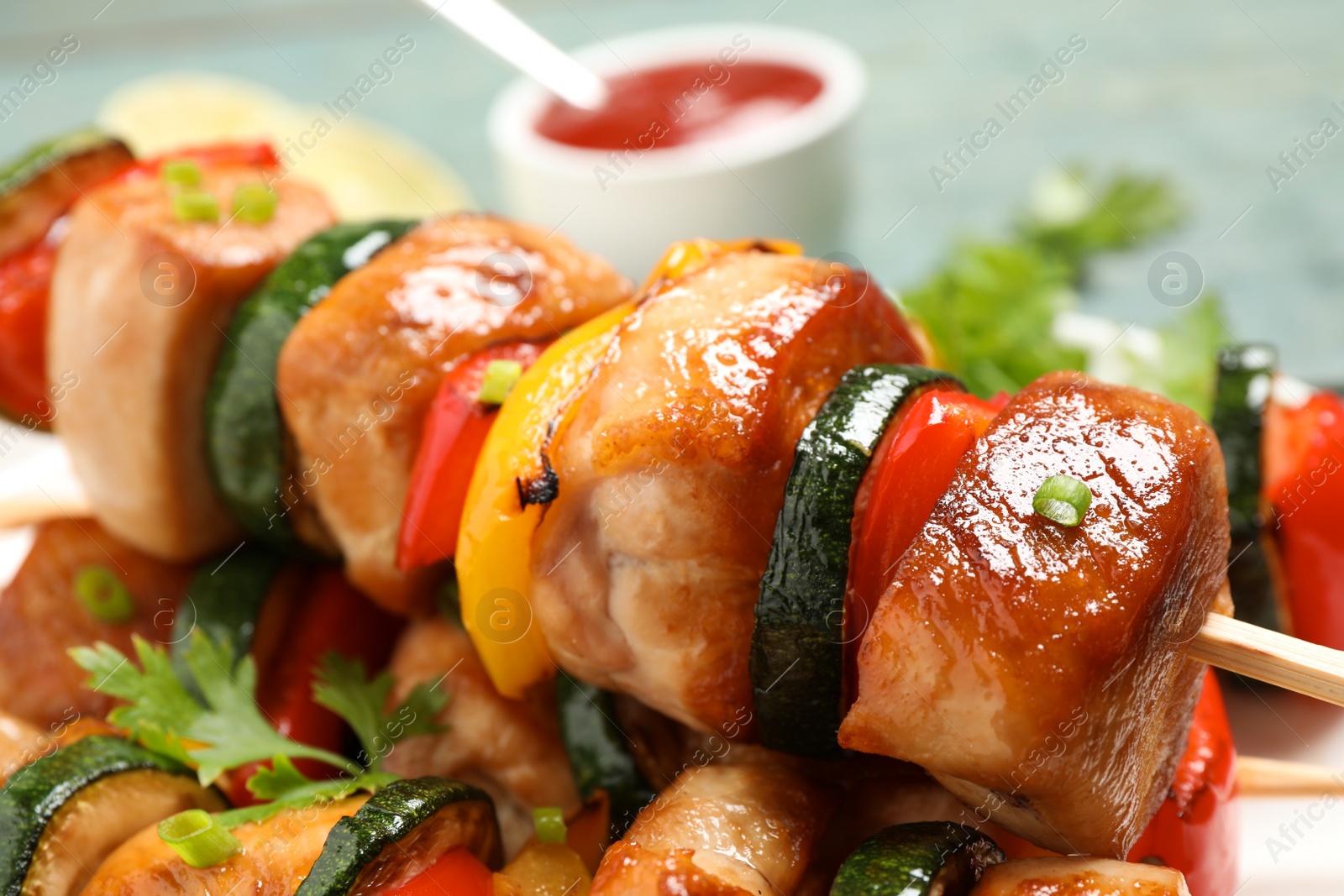 Photo of Delicious chicken shish kebabs with vegetables and parsley on plate, closeup