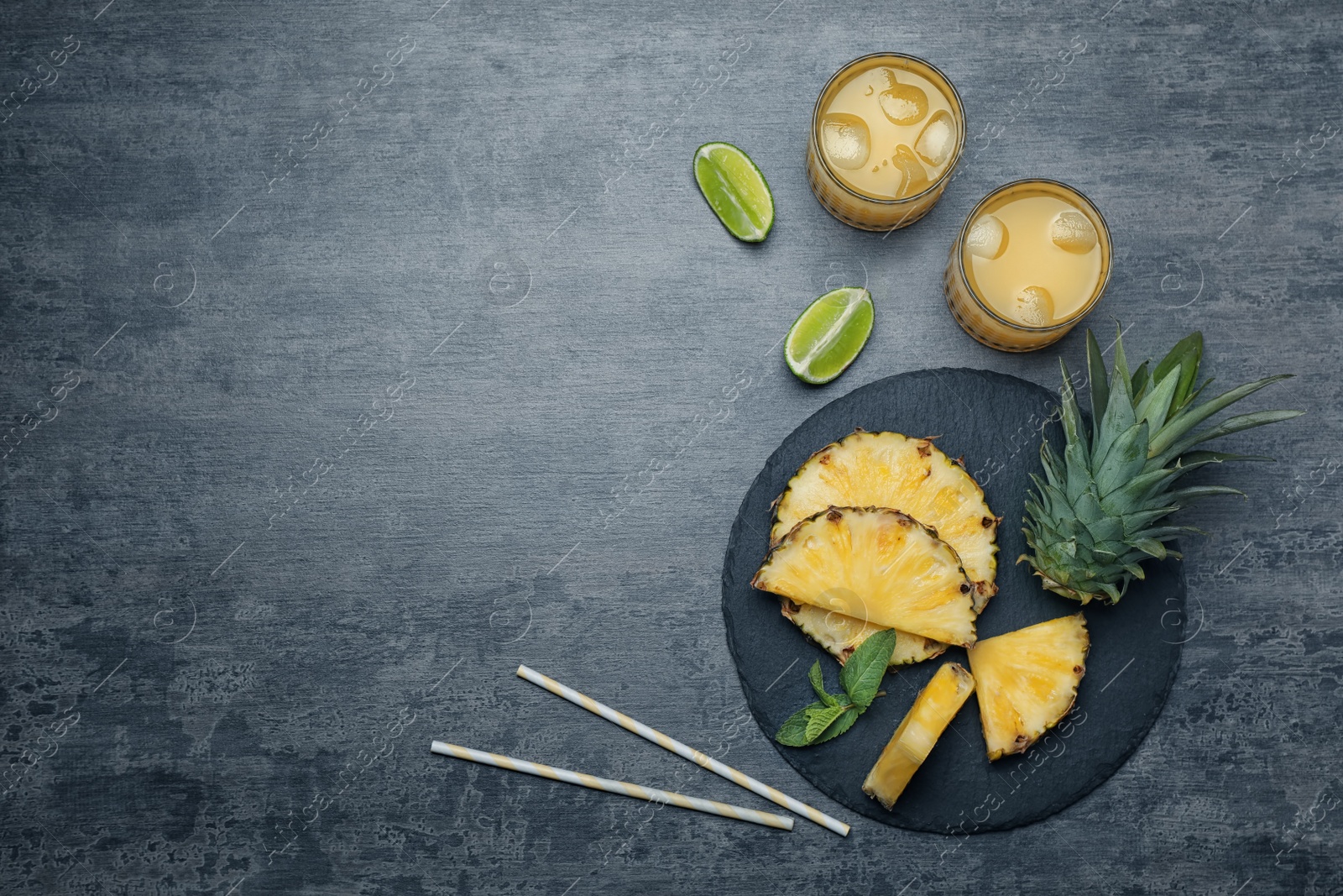 Photo of Flat lay composition with delicious pineapple juice on grey background