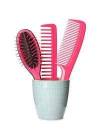 Photo of Hairbrush and combs in holder on white background