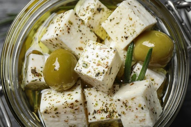 Top view of pickled feta cheese in jar, closeup