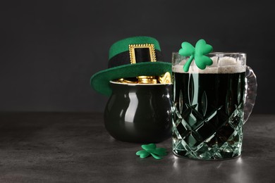 St. Patrick's day celebration. Green beer, leprechaun hat, pot of gold and decorative clover leaves on grey table. Space for text