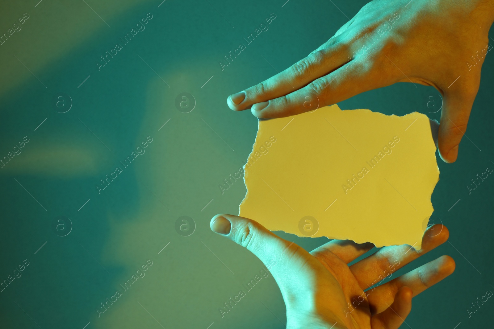 Photo of Man holding sheet of paper on color background, closeup and space for text. Color tone effect