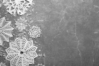 Photo of Flat lay composition with paper snowflakes on marble background, space for text. Winter season
