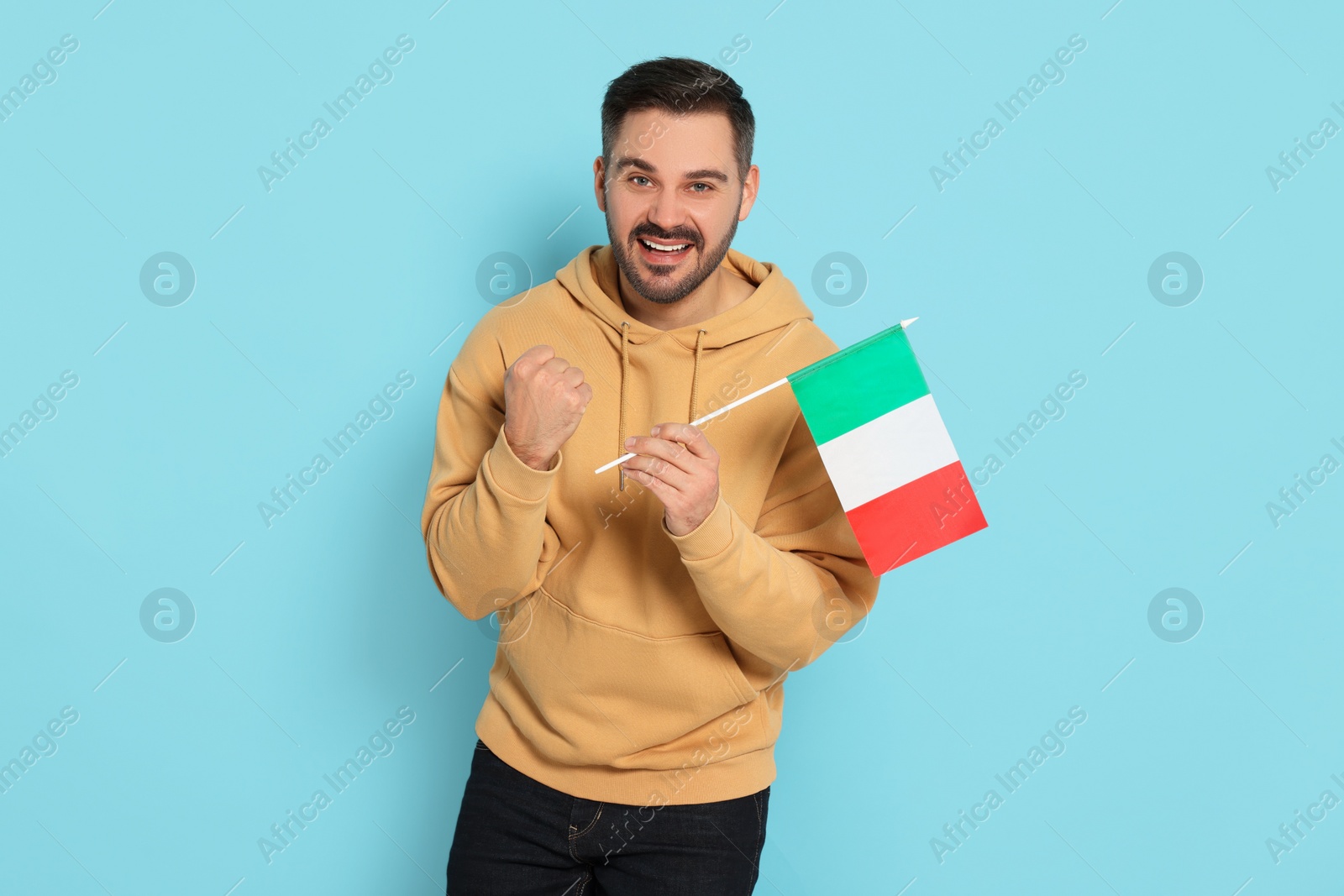 Photo of Man with flag of Italy on light blue background