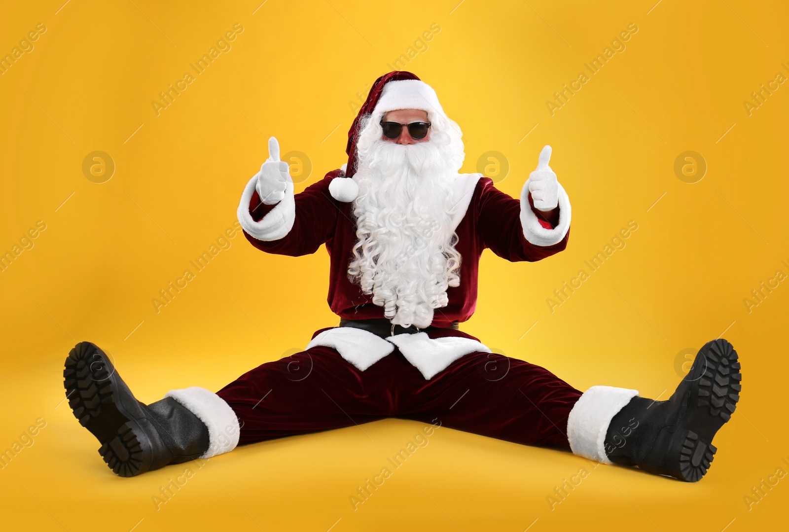 Photo of Santa Claus with sunglasses on yellow background