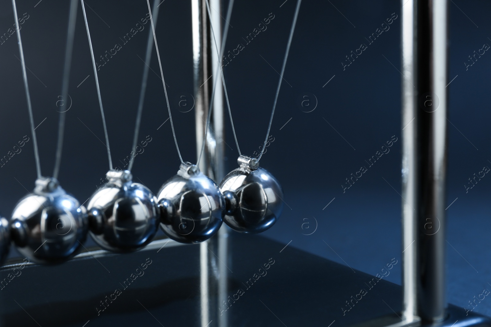 Photo of Newton's cradle on dark background, closeup. Physics law of energy conservation