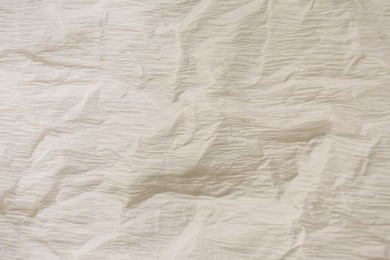 Photo of Texture of crumpled beige paper as background, closeup view