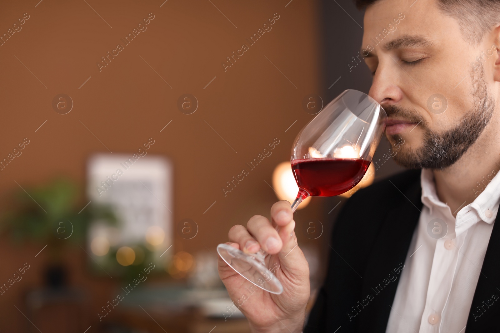 Photo of Young man with glass of wine indoors