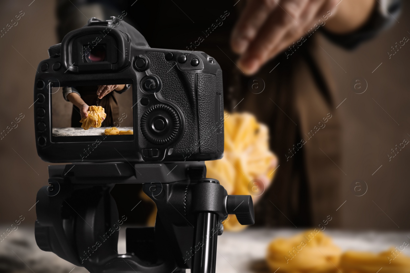 Image of Food photography. Shooting of woman making pasta, focus on camera