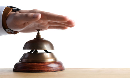 Photo of Man ringing hotel service bell at wooden table