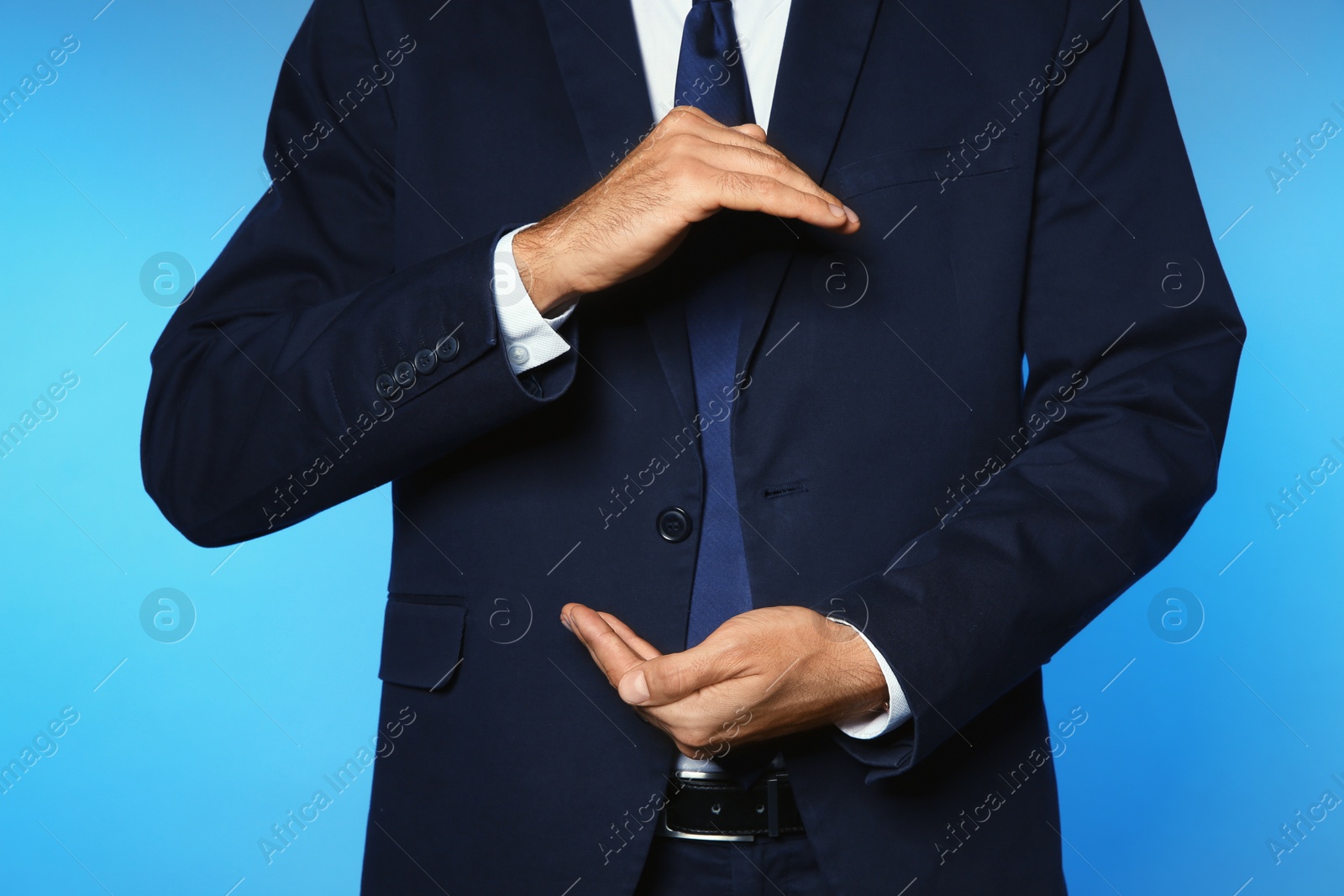 Photo of Businessman holding something on color background, closeup of hands