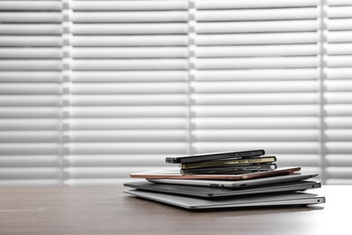 Photo of Many different modern gadgets on wooden table indoors. Space for text