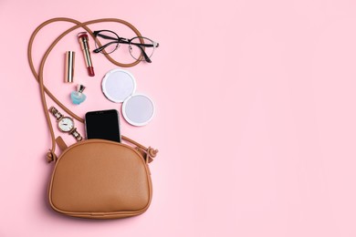 Photo of Stylish woman's bag with smartphone and accessories on pink background, flat lay. Space for text