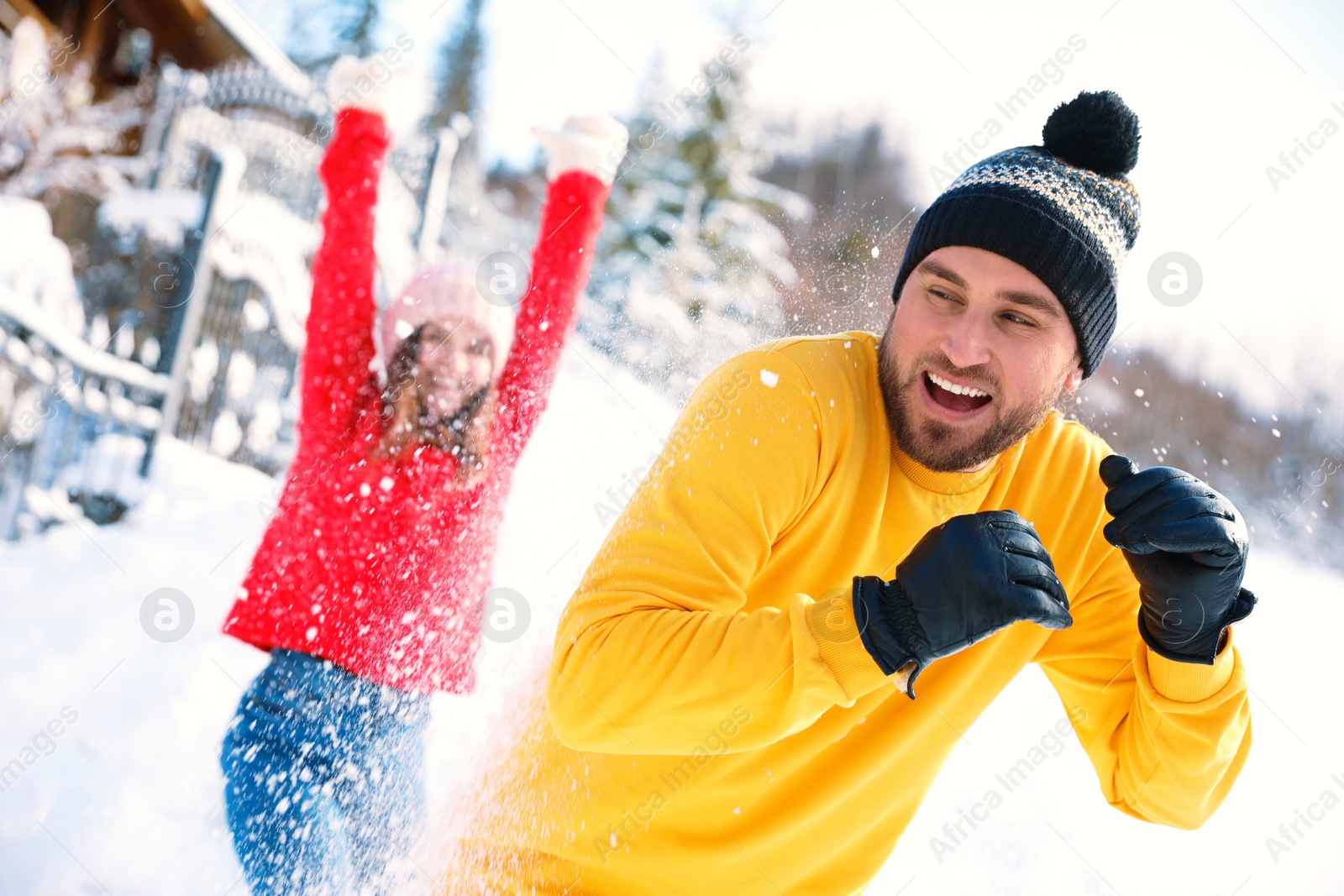 Photo of Happy couple playing snowballs outdoors. Winter vacation