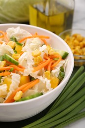 Photo of Tasty salad with Chinese cabbage, carrot, corn, cucumber and green onion on table, closeup