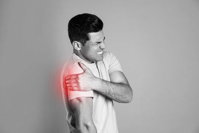 Image of Man suffering from shoulder pain. Black and white photo 