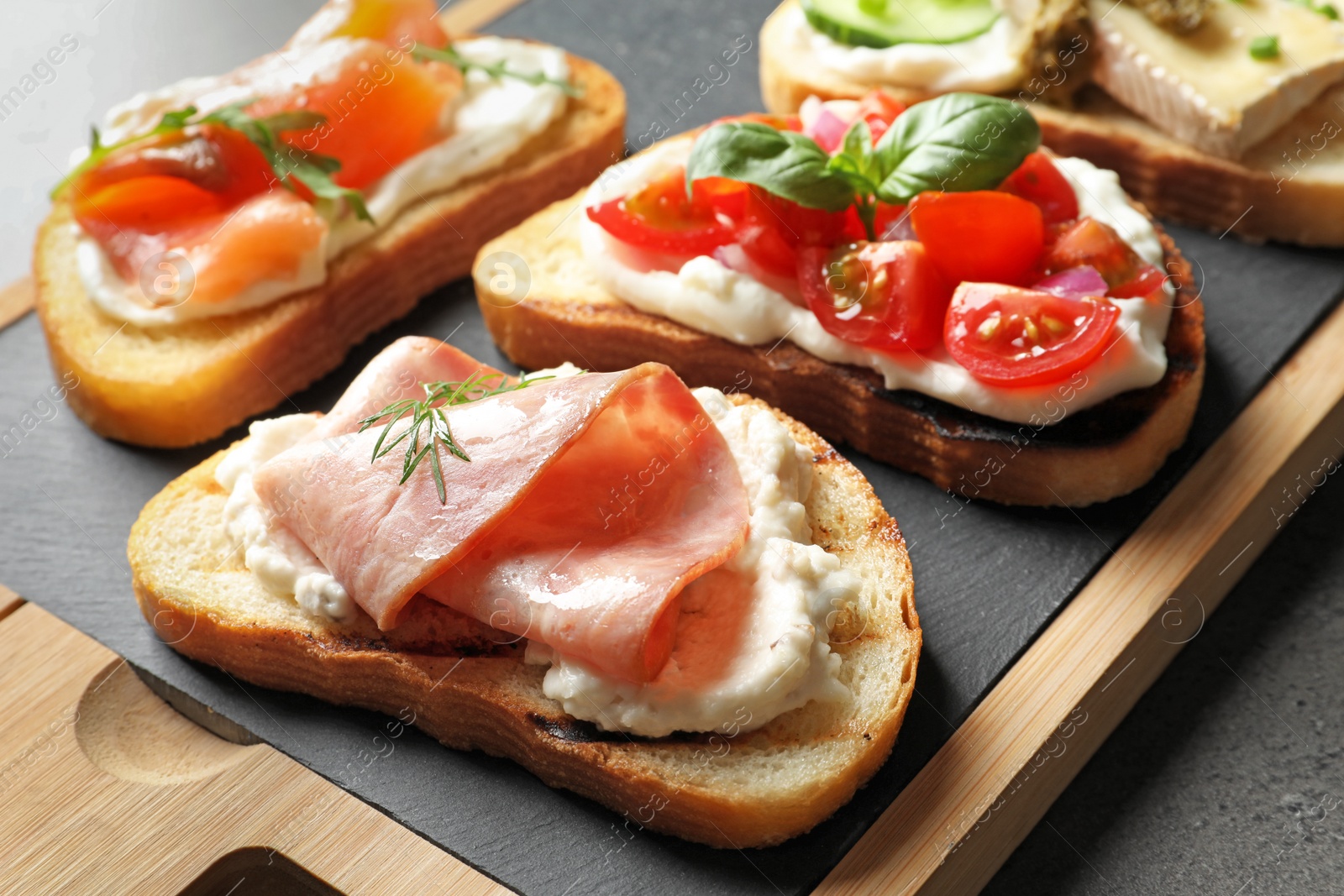 Photo of Board with different tasty bruschettas on table, closeup