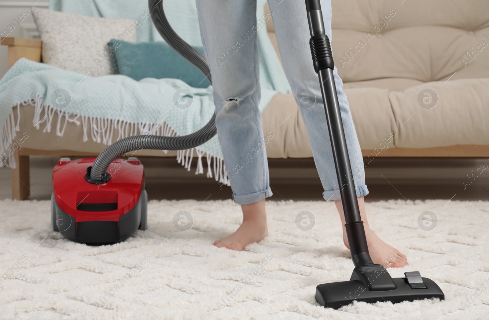 Photo of Woman cleaning carpet with vacuum cleaner at home, closeup