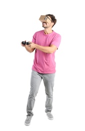 Young man using cardboard virtual reality headset, isolated on white