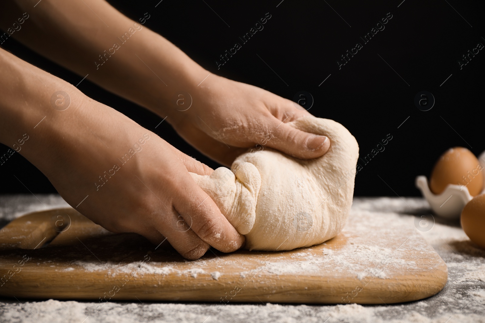 Photo of Woman with dough at grey table, closeup. Making pasta