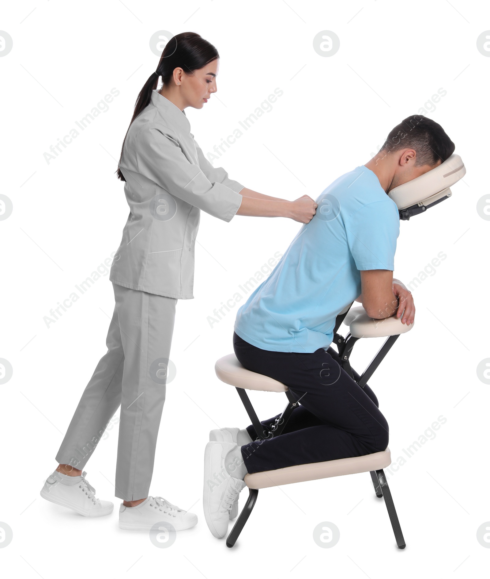 Photo of Man receiving massage in modern chair on white background