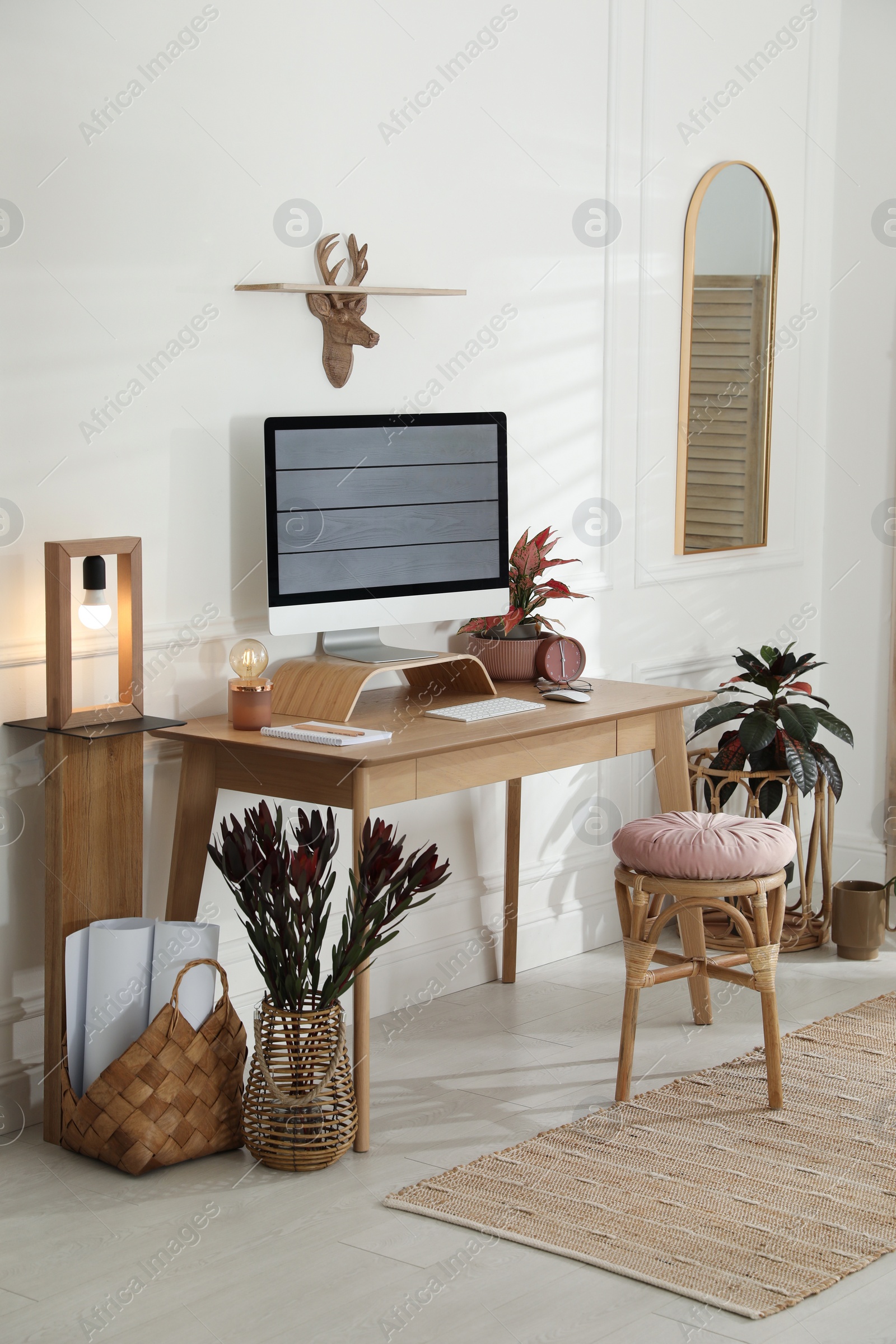 Photo of Comfortable workplace with modern computer and beautiful plants in room. Interior design