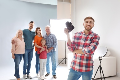 Photo of Professional photographer with camera and family in studio