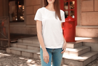 Photo of Young woman wearing white t-shirt on street