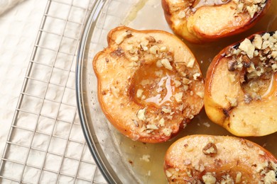 Photo of Delicious baked quinces with nuts and honey in bowl on table, top view