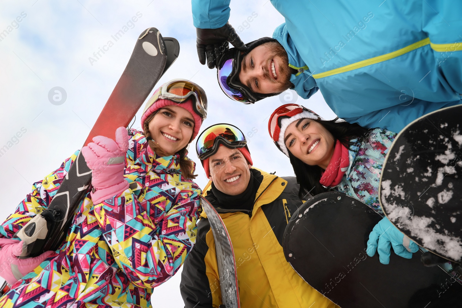 Photo of Group of friends joined in circle outdoors, bottom view. Winter vacation