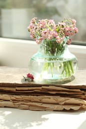 Photo of Beautiful Forget-me-not flowers and old book on window sill