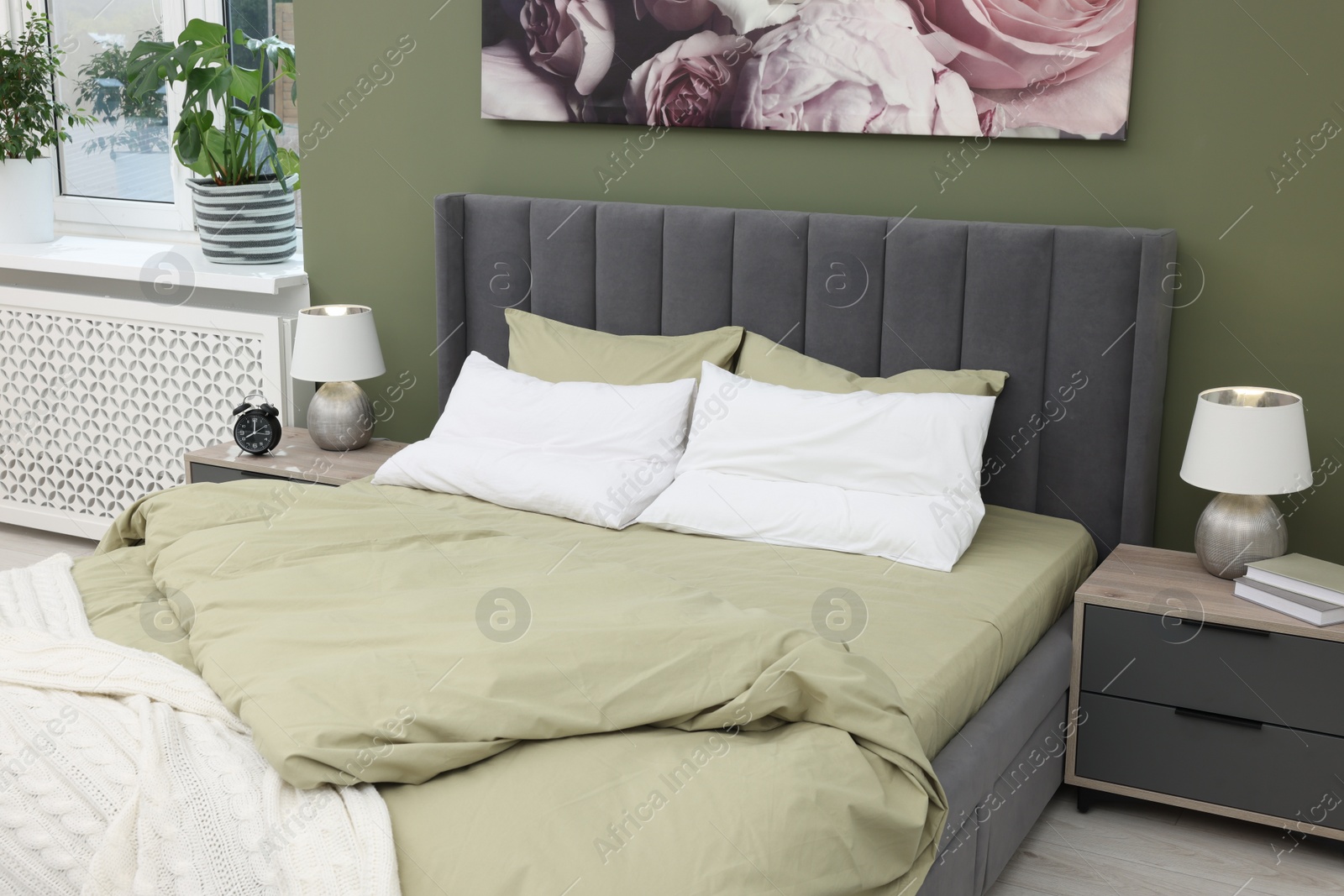 Photo of Comfortable bed and bedside tables with lamps in bedroom. Stylish interior design