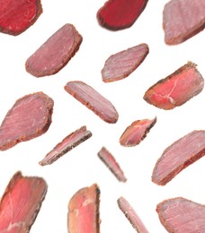 Slices of delicious dry-cured basturma falling on white background
