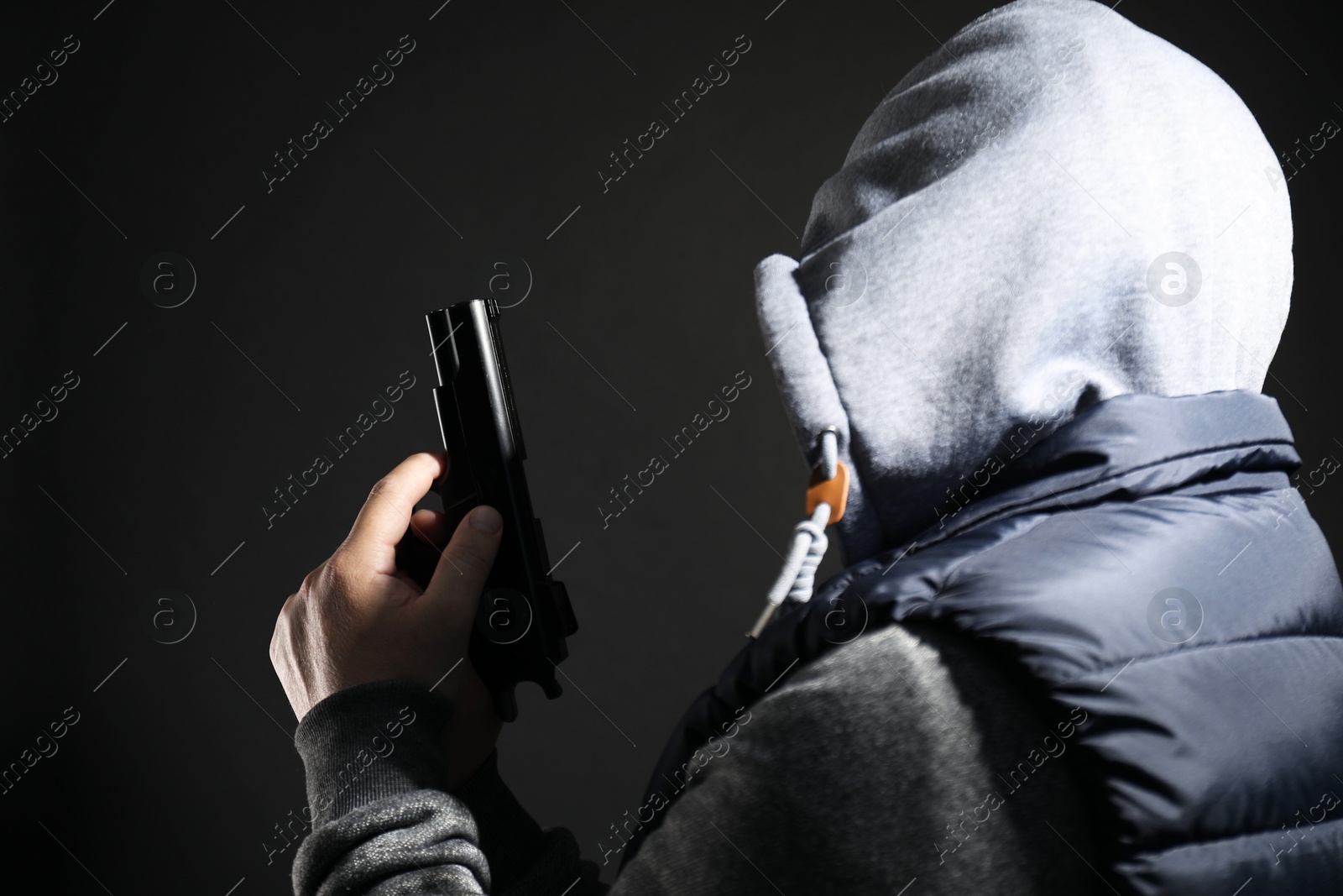 Photo of Dangerous criminal with gun on black background. Armed robbery