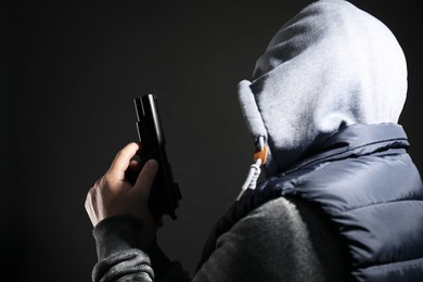 Photo of Dangerous criminal with gun on black background. Armed robbery