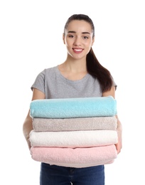 Happy young woman holding clean towels on white background. Laundry day