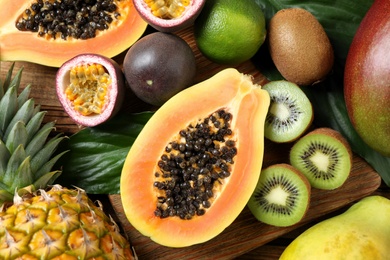 Photo of Fresh ripe papaya and other fruits on wooden table, flat lay
