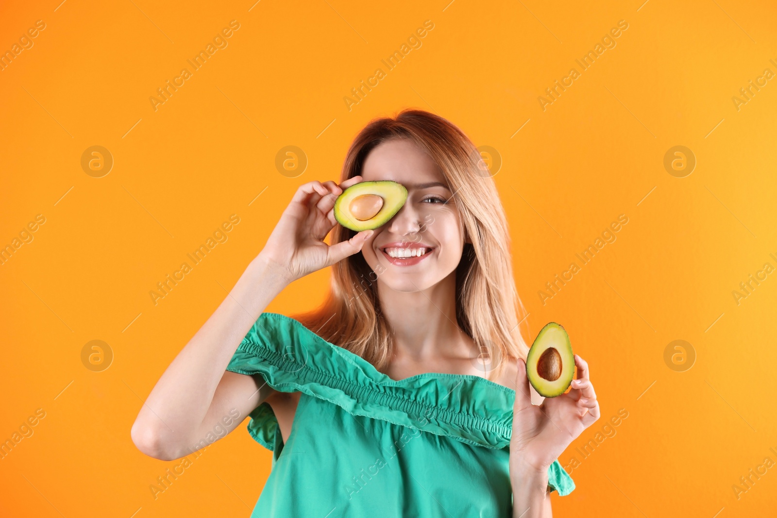 Photo of Portrait of young beautiful woman with ripe delicious avocado on color background