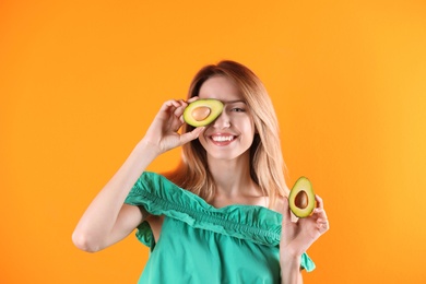 Photo of Portrait of young beautiful woman with ripe delicious avocado on color background