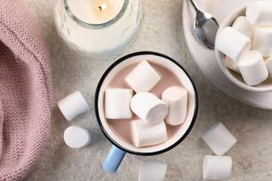 Photo of Cup of aromatic hot chocolate with marshmallows served on beige table, flat lay