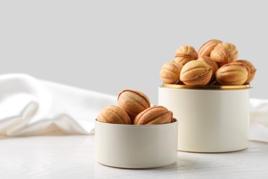 Delicious nut shaped cookies on white wooden table, space for text