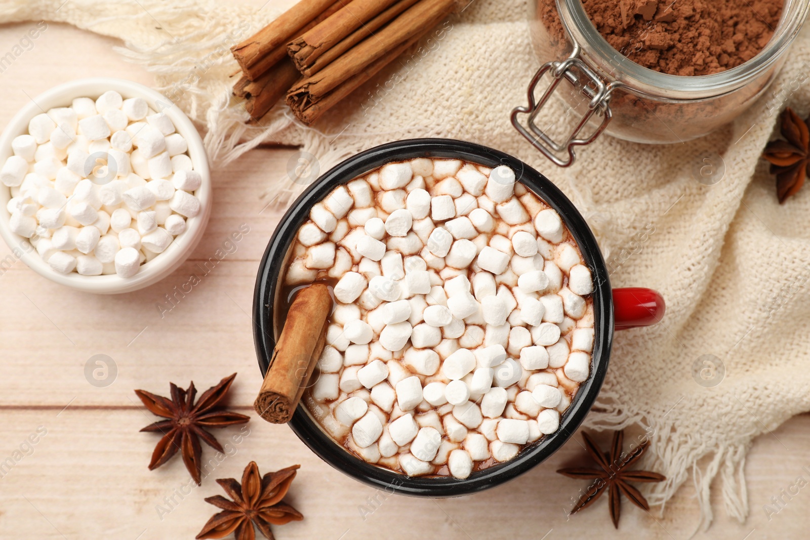 Photo of Tasty hot chocolate with marshmallows and ingredients on white wooden table, flat lay