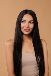 Photo of Beautiful woman with long hair on beige background